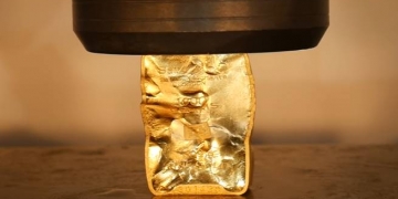 Como o ouro se comporta numa prensa hidráulica?