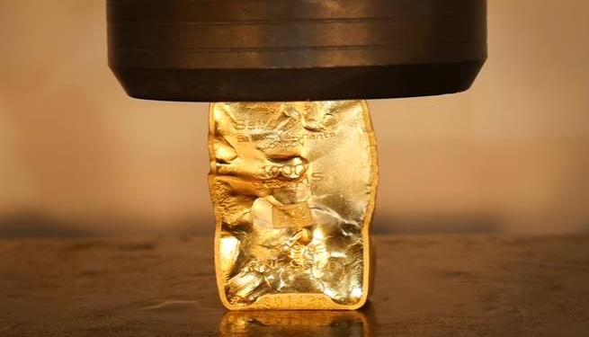 Como o ouro se comporta numa prensa hidráulica?